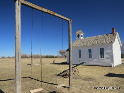 An old schoolhouse with swing set and Teeter Totter at Stuhr Museum