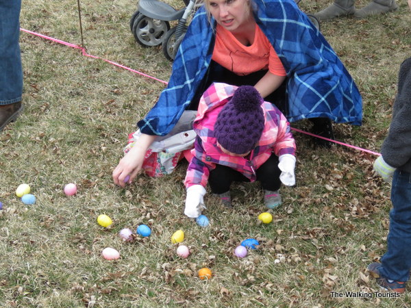 Child picking up plastic Easter eggs during egg hunt at Spring Fling