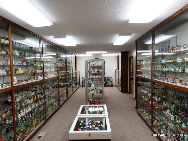 Room with glass-enclosed shelves featuring all types of salt and pepper shaker sets