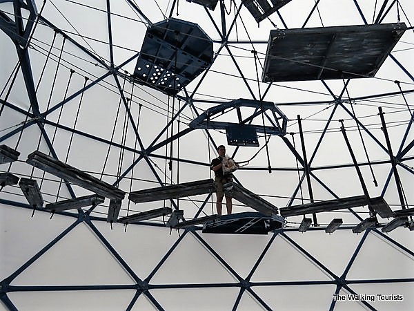 A staff member stands on the second level of obstacles inside the Challenge Dome.