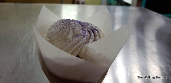 Cupcake with paper packaging and purple sprinkles on top