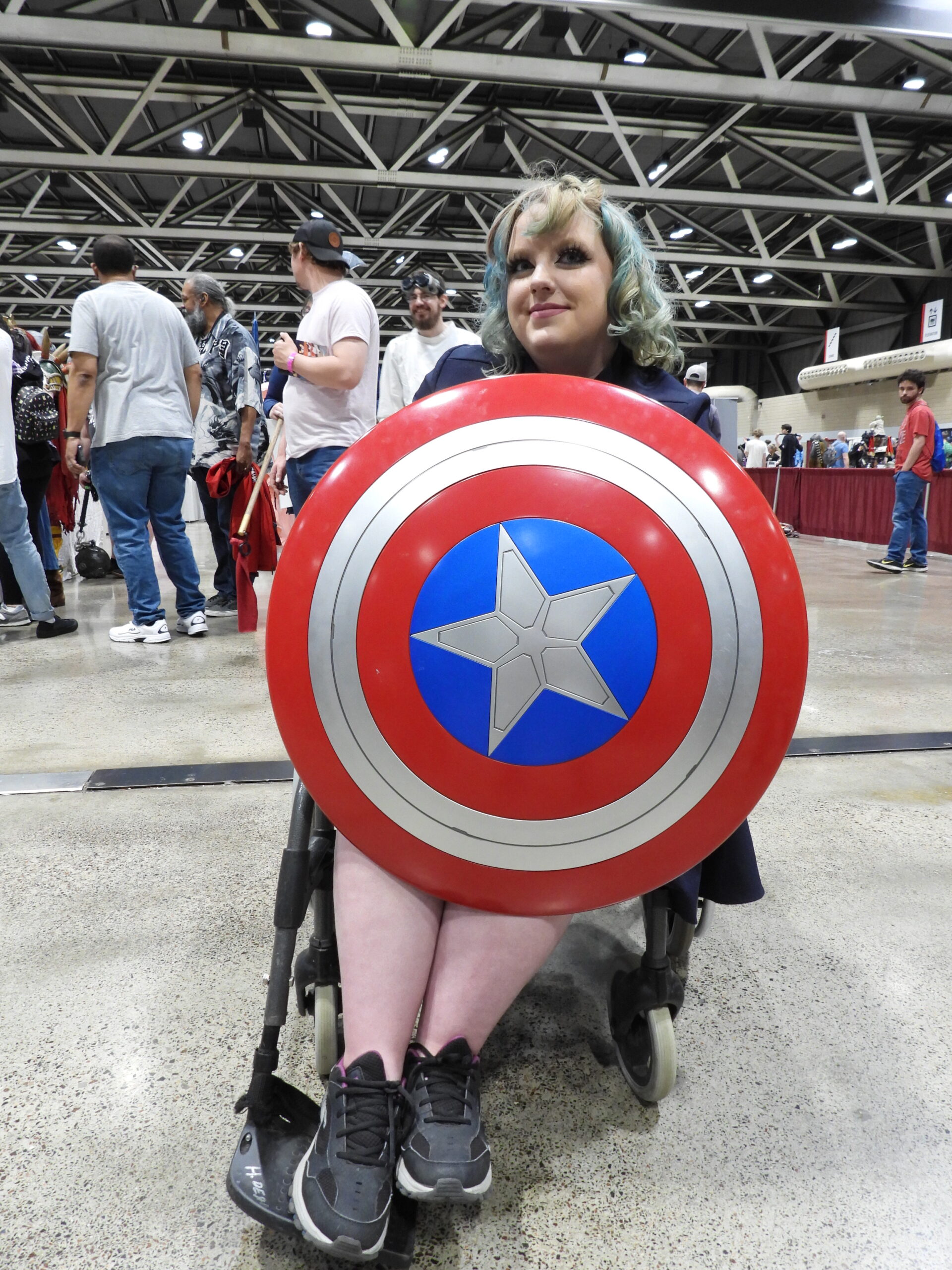 Wheelchair attendee displays her Captain America shield