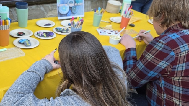 Children hand paint small rocks.